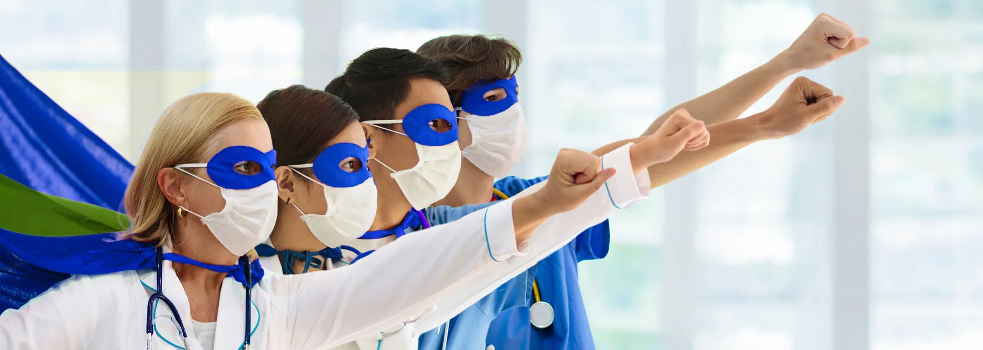 Des professionnelles et des professionnels de la santé portent des capes et des masques de superhéros et ont un bras tendu à l’avant.