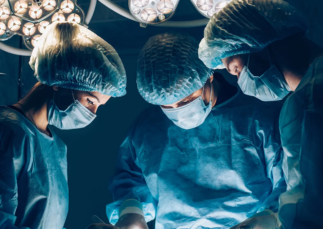 Trois personnes qui effectuent une chirurgie.