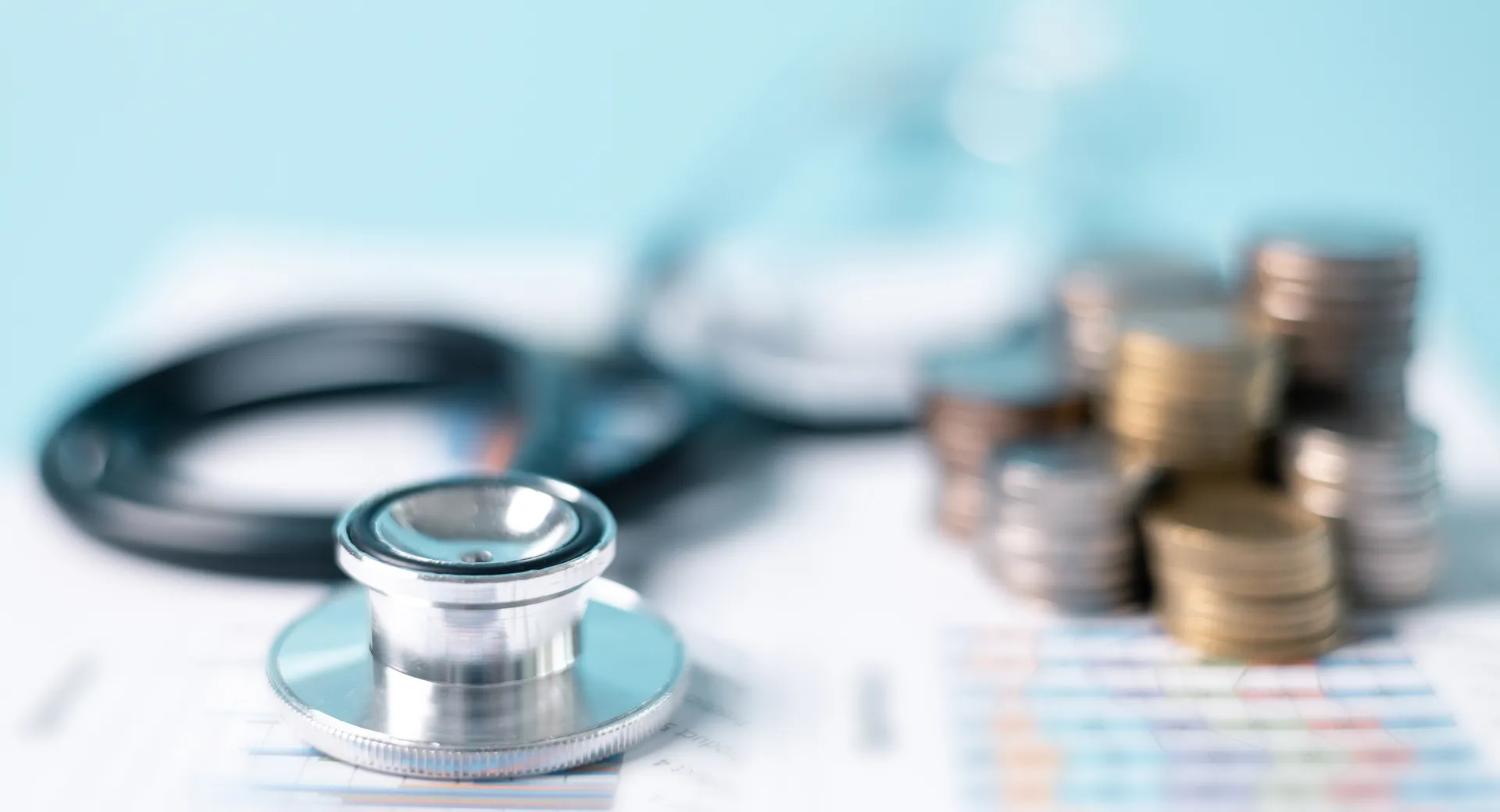 Une image représentant une pile de pièces de monnaie et un stéthoscope.