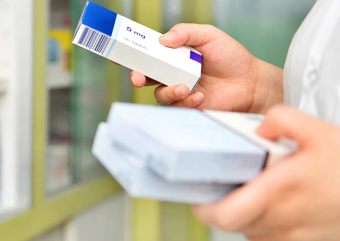 Une personne manipule des boîtes contenant des médicaments.